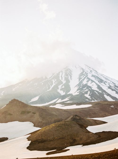 Free Stunning view of a snow-covered volcano under a misty sky in Kamchatka, Russia. Stock Photo