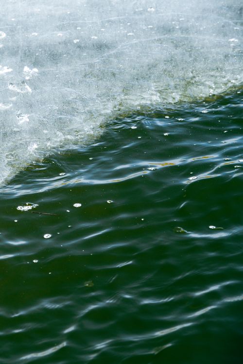 Free Detailed view of waves meeting ice on a serene lake surface, showcasing natural beauty. Stock Photo