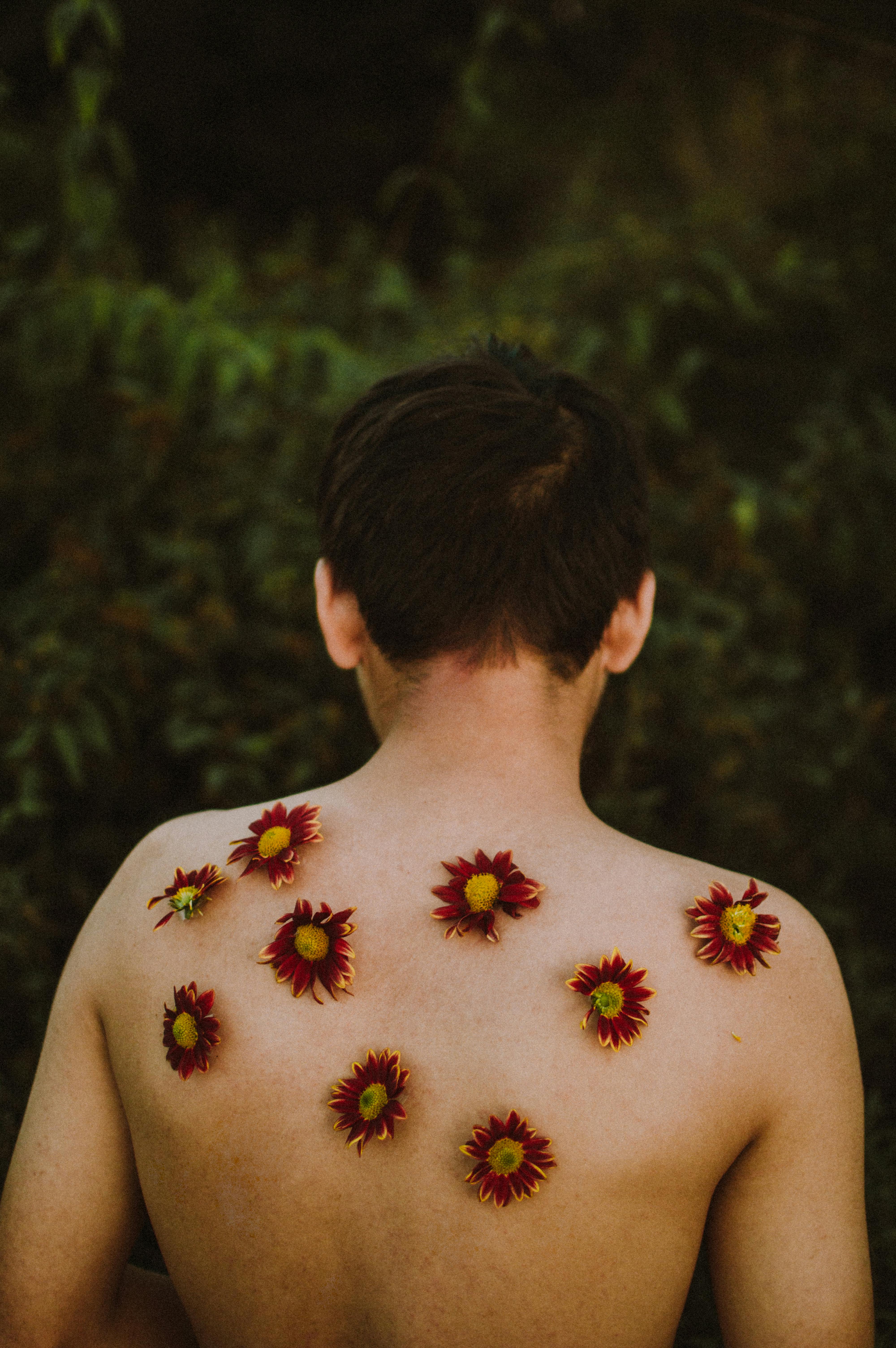 Artistic portrait featuring a back view adorned with flowers in a natural setting, captured in Mexico.