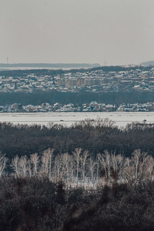 Free Aerial winter view of a snow-covered town in Ufa, Russia, surrounded by forests. Stock Photo