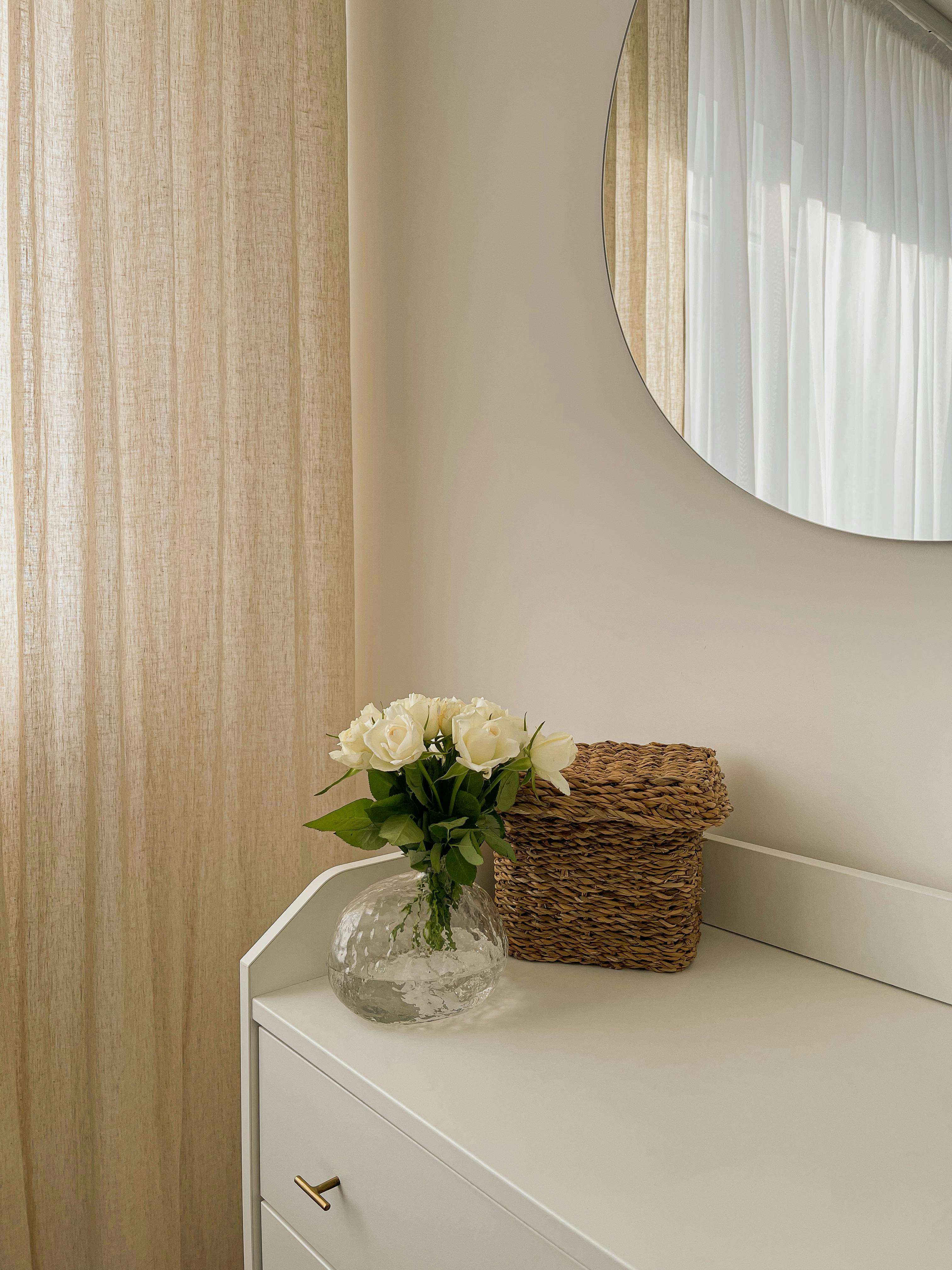 Stylish interior featuring roses in a vase, woven basket, and minimalist decor.