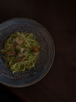 Delicious shrimp pasta in a rich pesto sauce, styled on a rustic plate in Estonia.