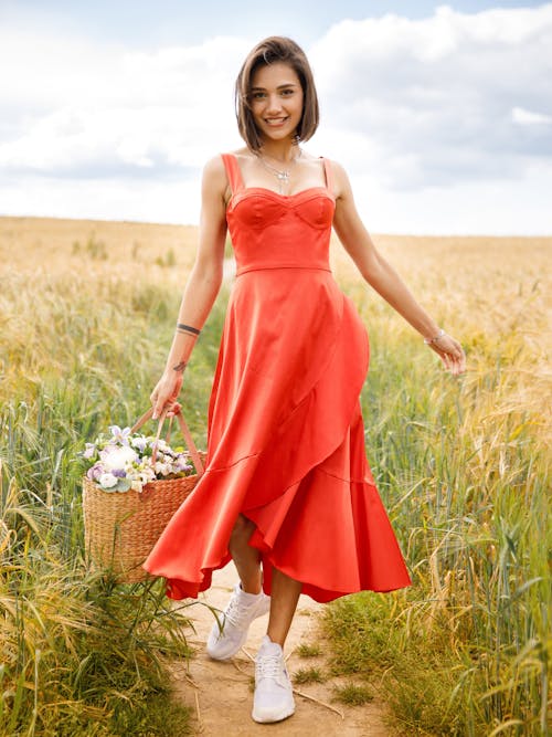 Smiling Young Woman Walking on the Meadow