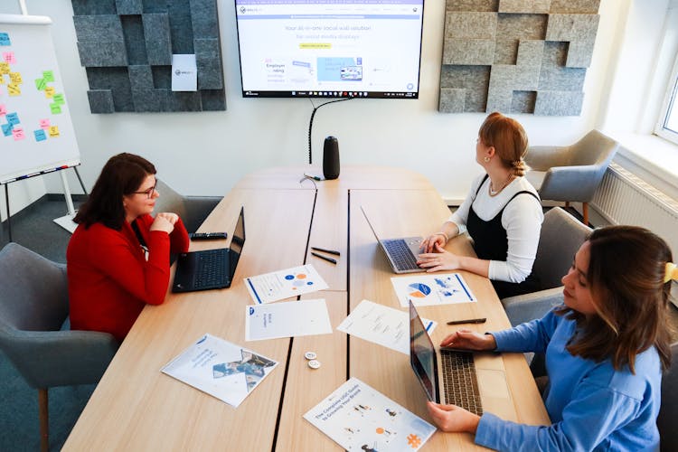 Women Sitting In A Boardroom And Talking During A Business Meeting 