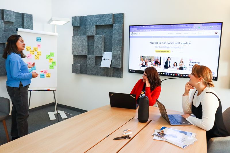 Diverse team brainstorming brand strategy around a table with mood boards