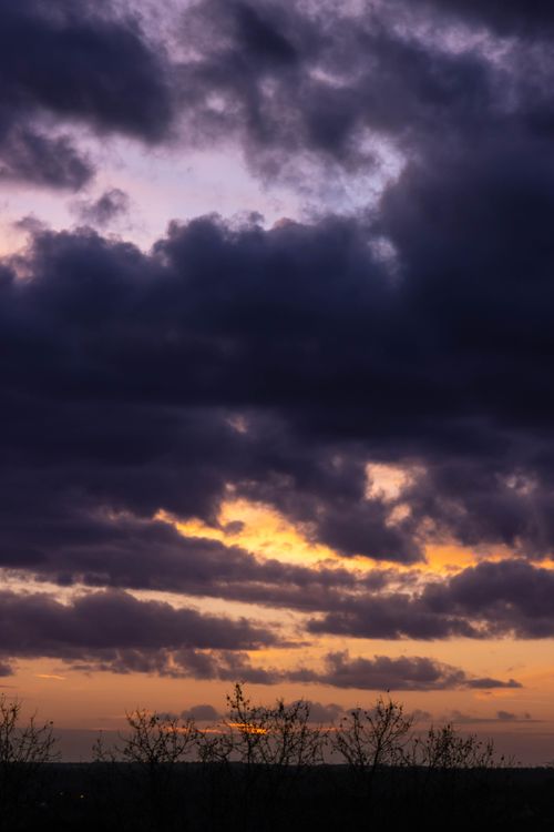 Free Beautiful sunset with dramatic clouds casting shadows over a serene landscape, creating a stunning natural scene. Stock Photo