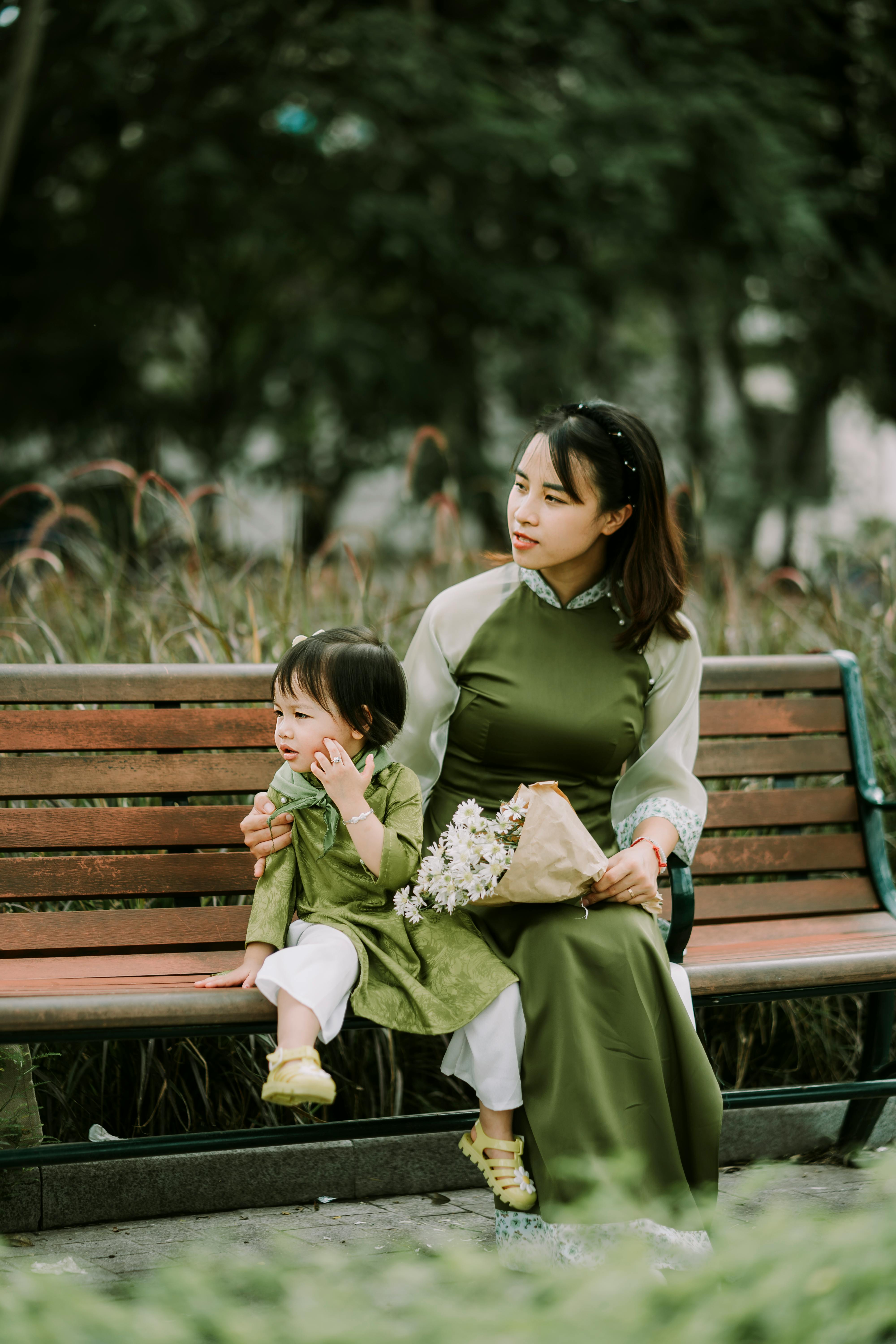 woman and her little daughter sitting on a bench