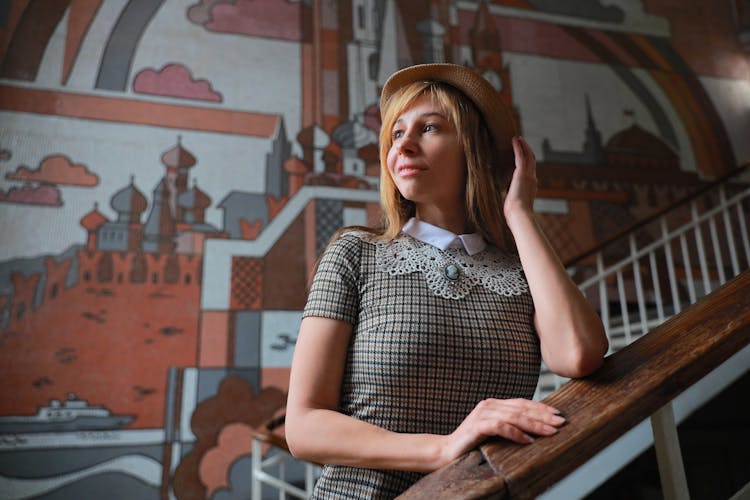 Woman Posing With Mural On Wall Behind