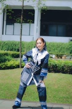 Young woman in fashionable attire posing outdoors in a park in Bandung.