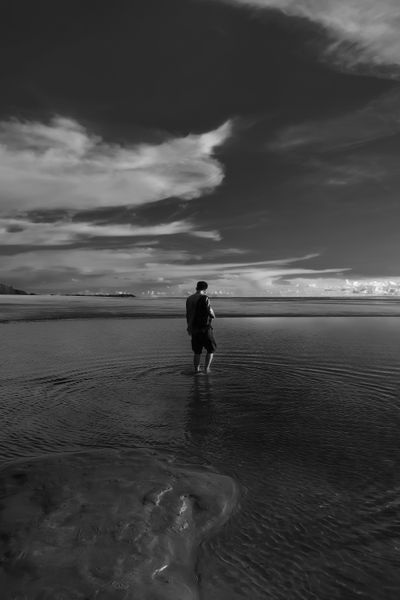 A lone figure standing in shallow water, photo by Mah mud on Pexels