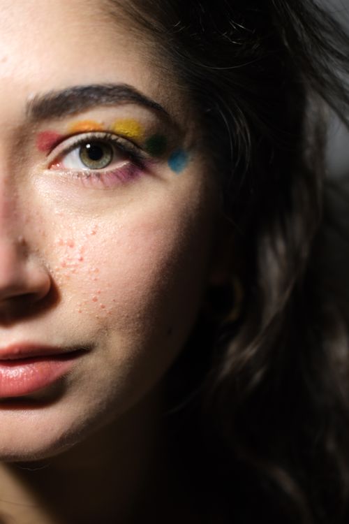 Free Artistic close-up of a woman's face with colorful eye makeup highlighting her eye. Stock Photo