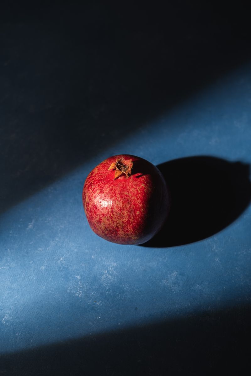 A whole pomegranate, used to finish the walnut-and-herb pkhali spreads