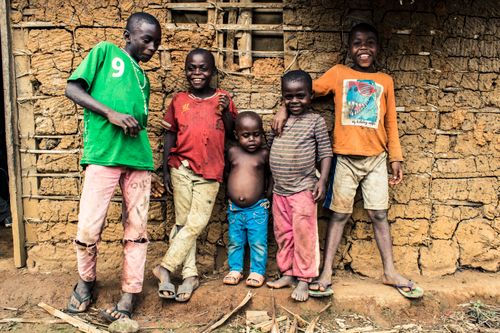 Free Group of smiling children standing in front of a rustic wall in Mintom, Cameroon. Stock Photo