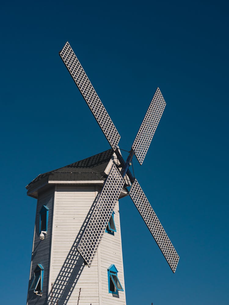 A Vintage Windmill On The Background Of A Blue Sky 