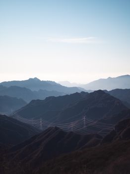 Stunning view of mountains with power lines under clear sky, perfect for backgrounds.