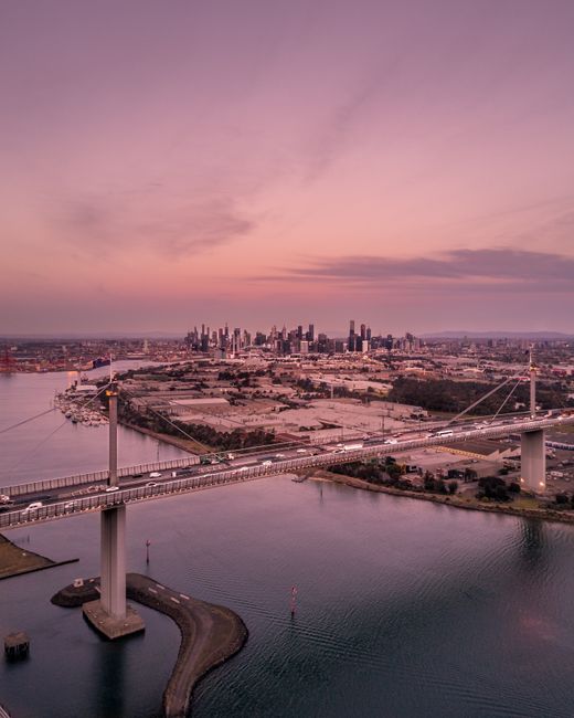 Stunning aerial view of the West Gate Bridge over water at sunset in Melbourne, Australia.