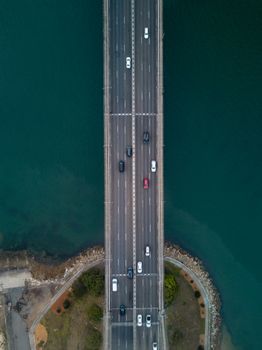 白天鸟瞰悉尼海港大桥上穿越蓝色水域的车辆