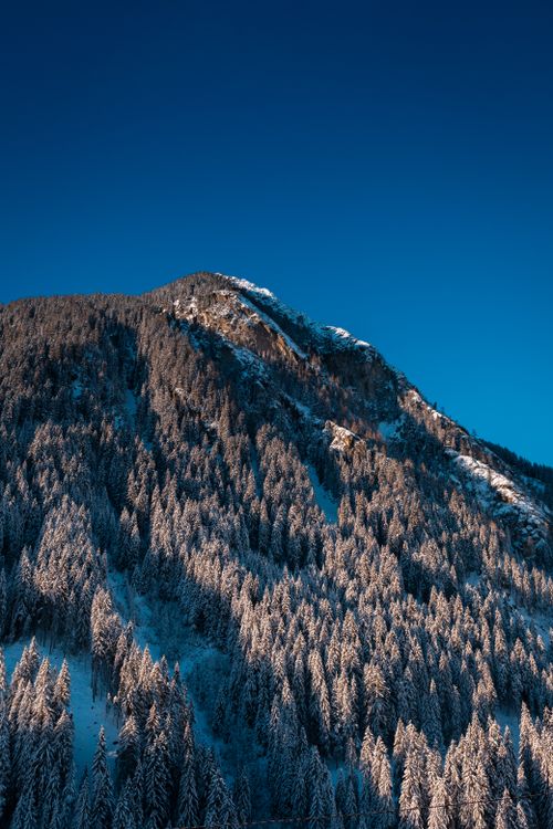 Free Snow-covered mountain landscape in Mayrhofen, Tirol, showcasing a pristine winter scene under a clear blue sky. Stock Photo