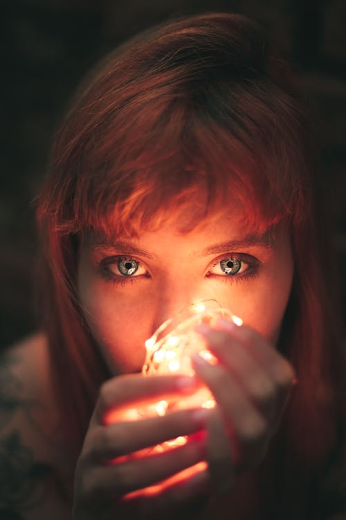 Free Close-up Photography of Woman Holding String Lights Stock Photo