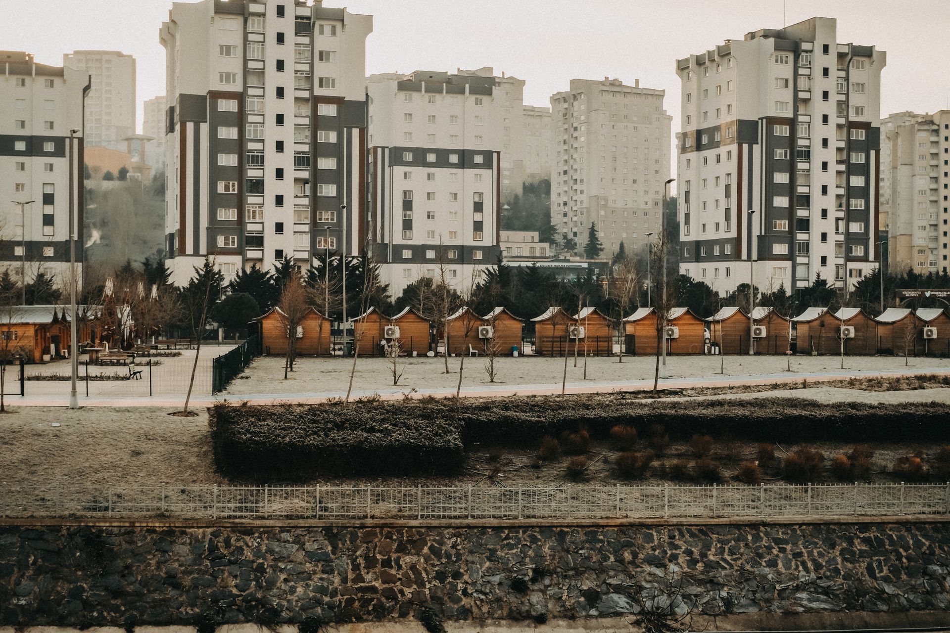 A winter view of modern residential buildings and wooden cabins in İstanbul, Türkiye.