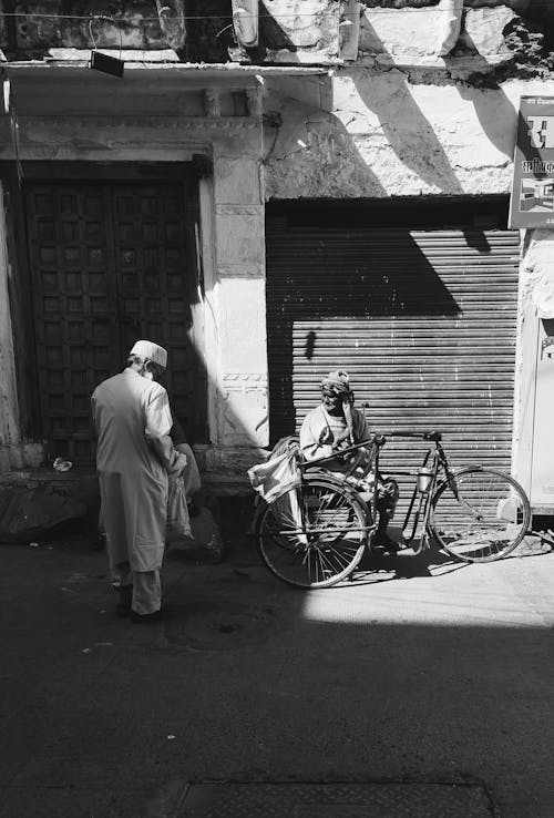 Two Men with a Bicycle on a Street 
