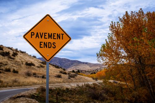 Free Autumn landscape featuring a 'Pavement Ends' sign along a rural road. Stock Photo