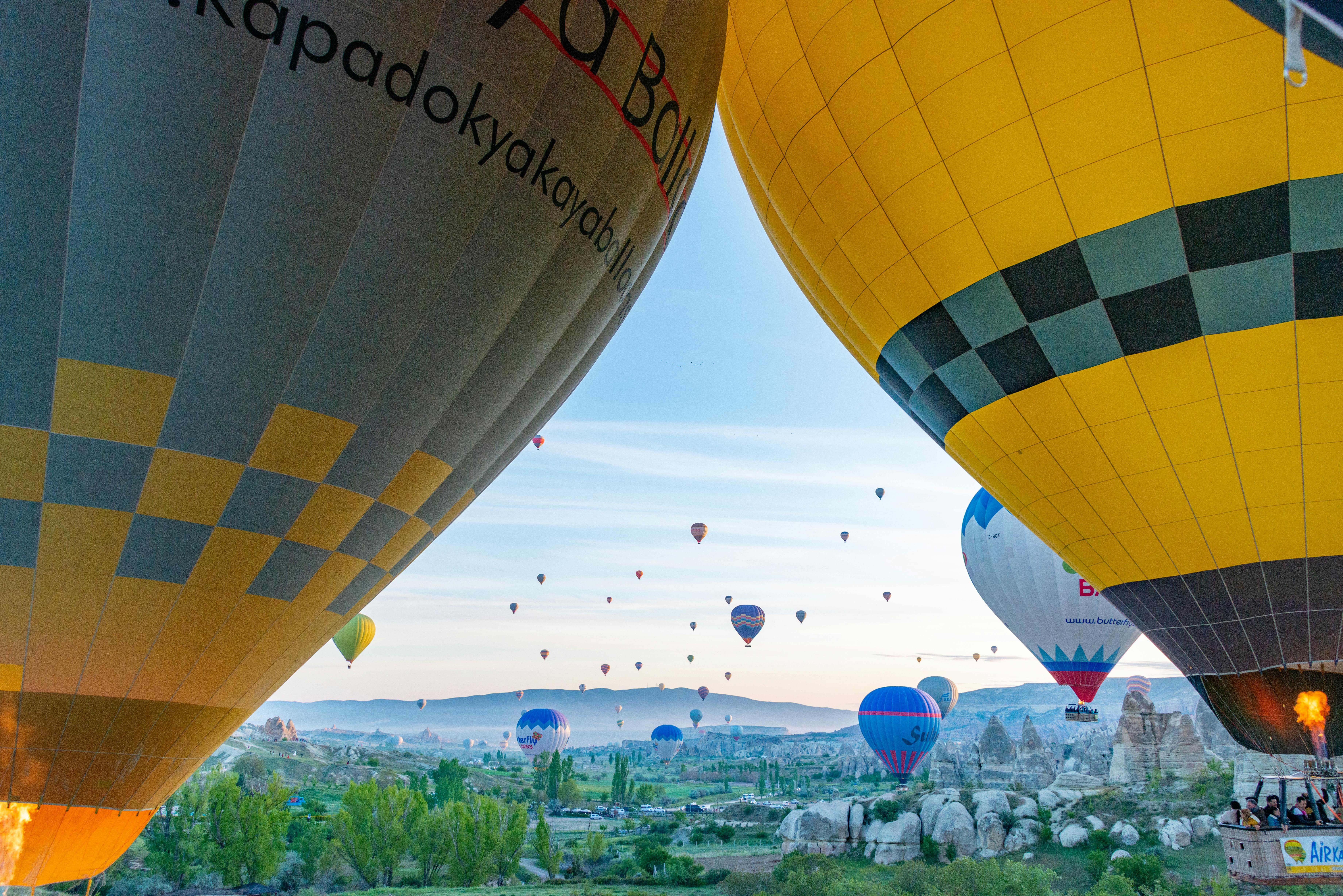 Vibrant sunrise with colorful hot air balloons in Cappadocia's scenic landscape. in Visit