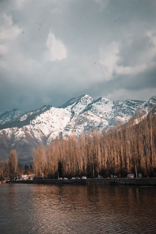Free Stunning view of snowcapped mountains reflected in a calm lake during winter. Stock Photo