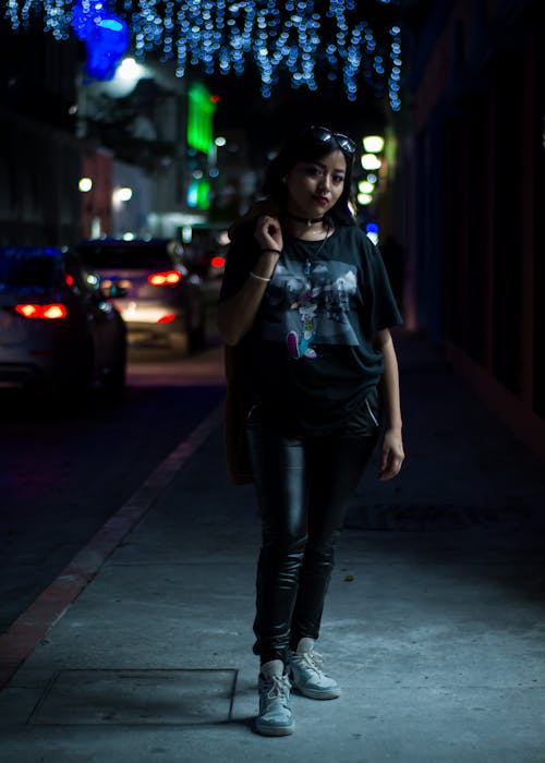 Woman Standing on a Sidewalk at Dusk 