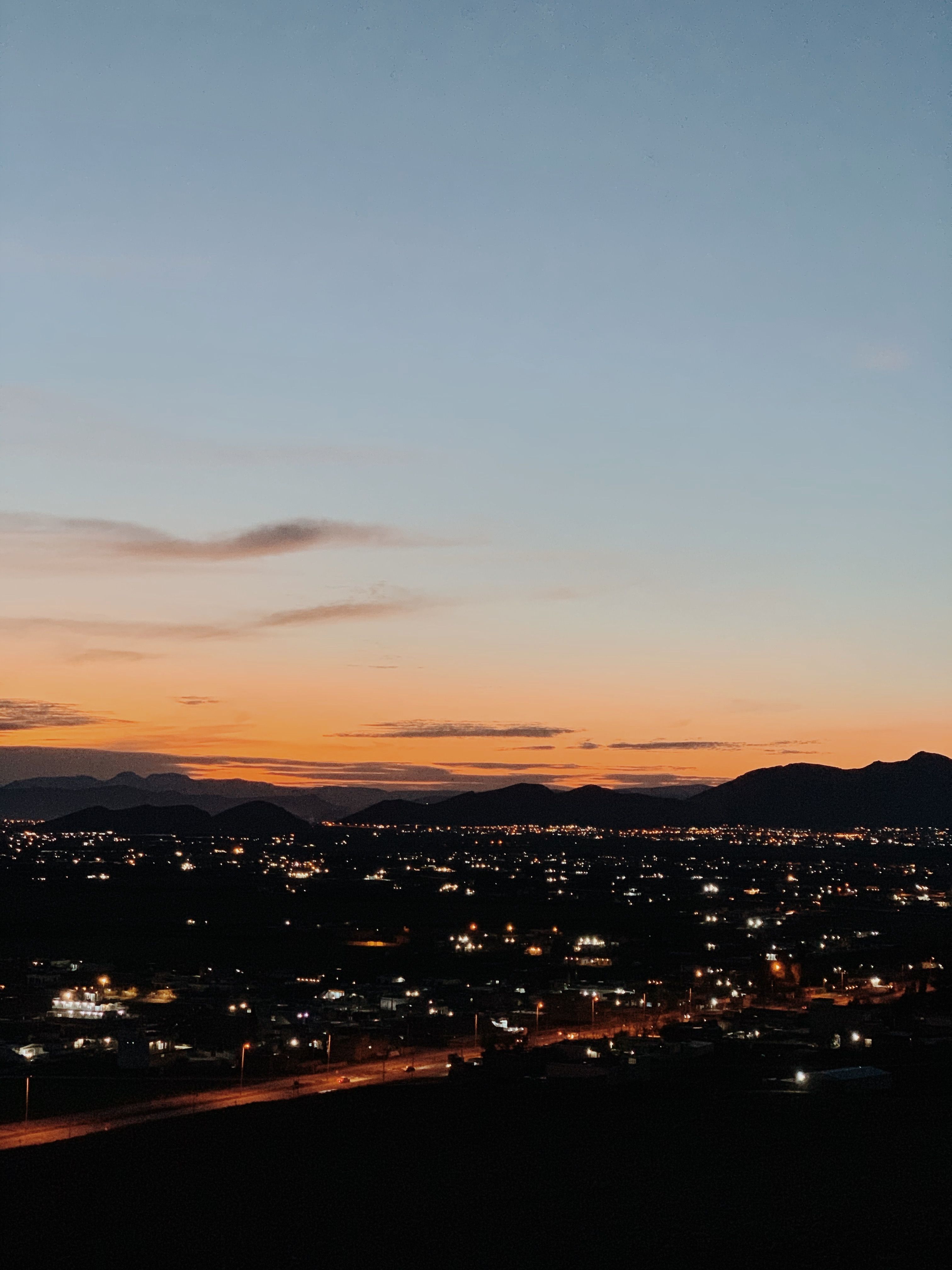 Aerial view of Qurago, Sulaymaniyah at sunset, highlighting urban landscape and distant mountains.