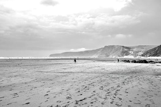 A tranquil monochrome photo of Watergate Bay beach, Cornwall, UK.