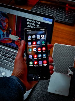 Close-up of a smartphone screen showcasing various apps in a tech-savvy workspace.