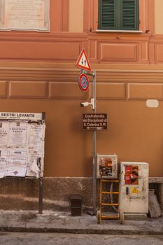 Urban street scene in Sestri Levante featuring signage and a building facade.