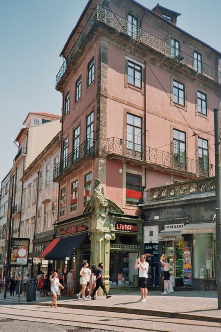 Vibrant street view of historic buildings and people in Porto, Portugal.