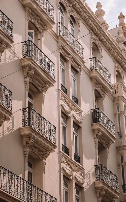 Free Ornate residential building facade with balconies in Valencia, Spain bathed in sunlight. Stock Photo