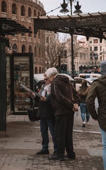 Elderly couple checking a map in the bustling streets of Valencia, Spain.