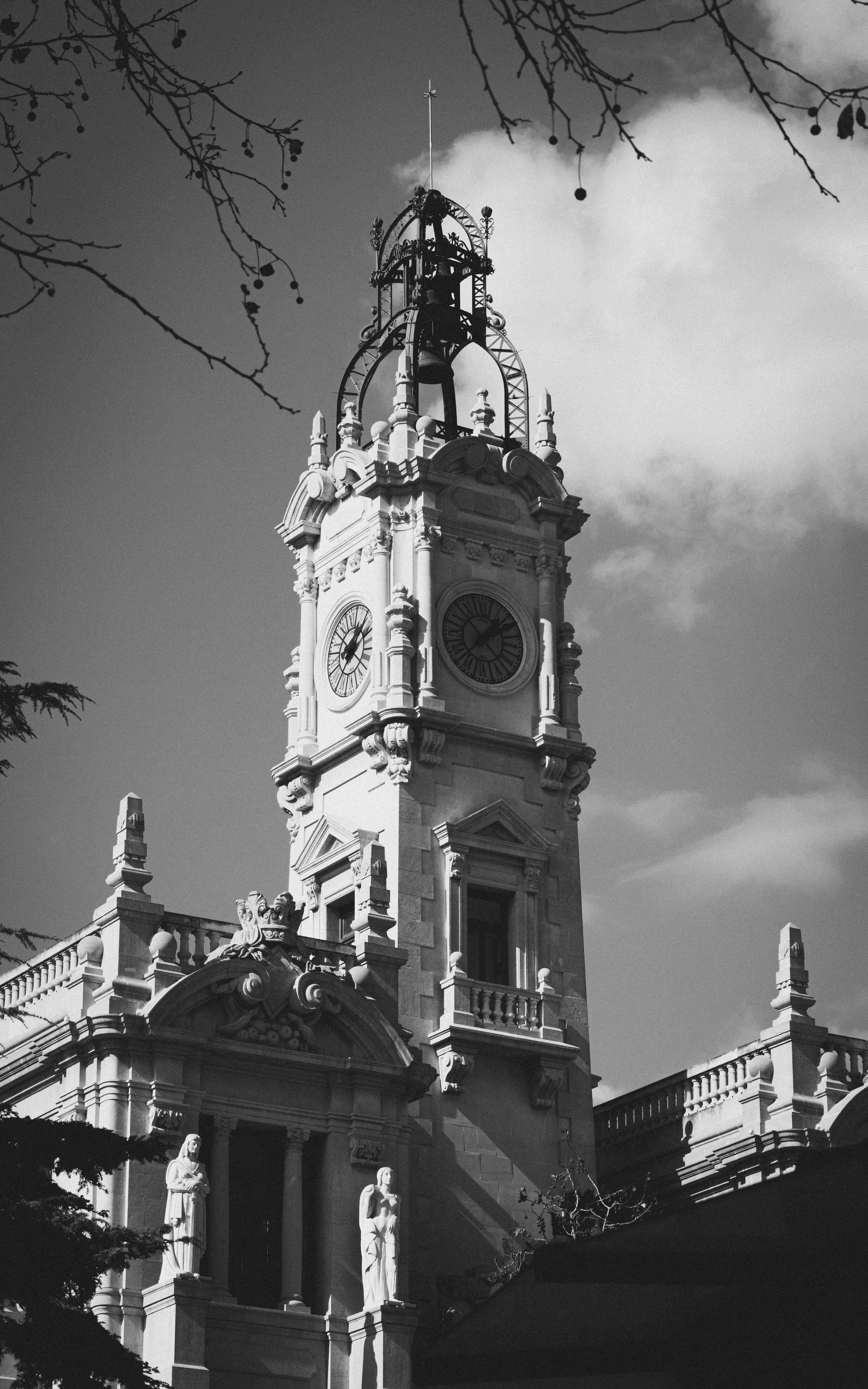 Black and white photo of a historic clock tower in Valencia, Spain showcasing architectural detail.