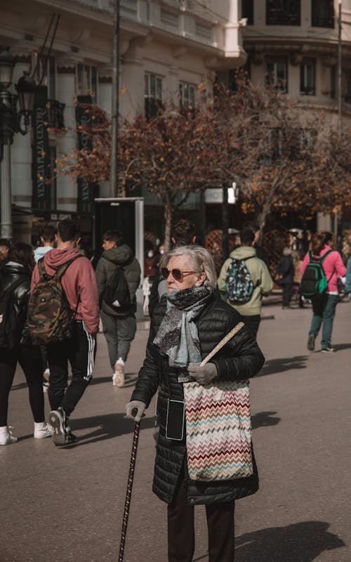 Photo of an Elderly Woman in a Crowded Street