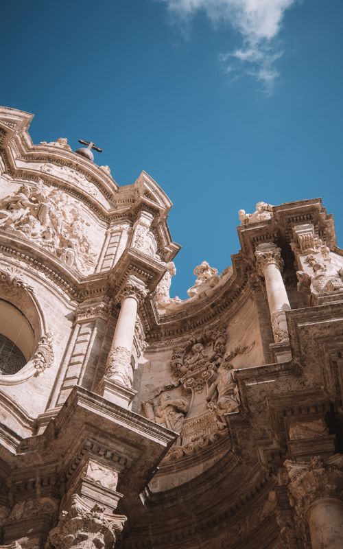 Free A detailed view of the Baroque architectural facade of Valencia Cathedral under a blue sky. Stock Photo