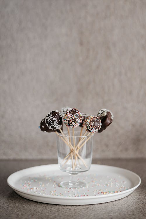 Chocolate Lollipops in a Glass on a White Plate