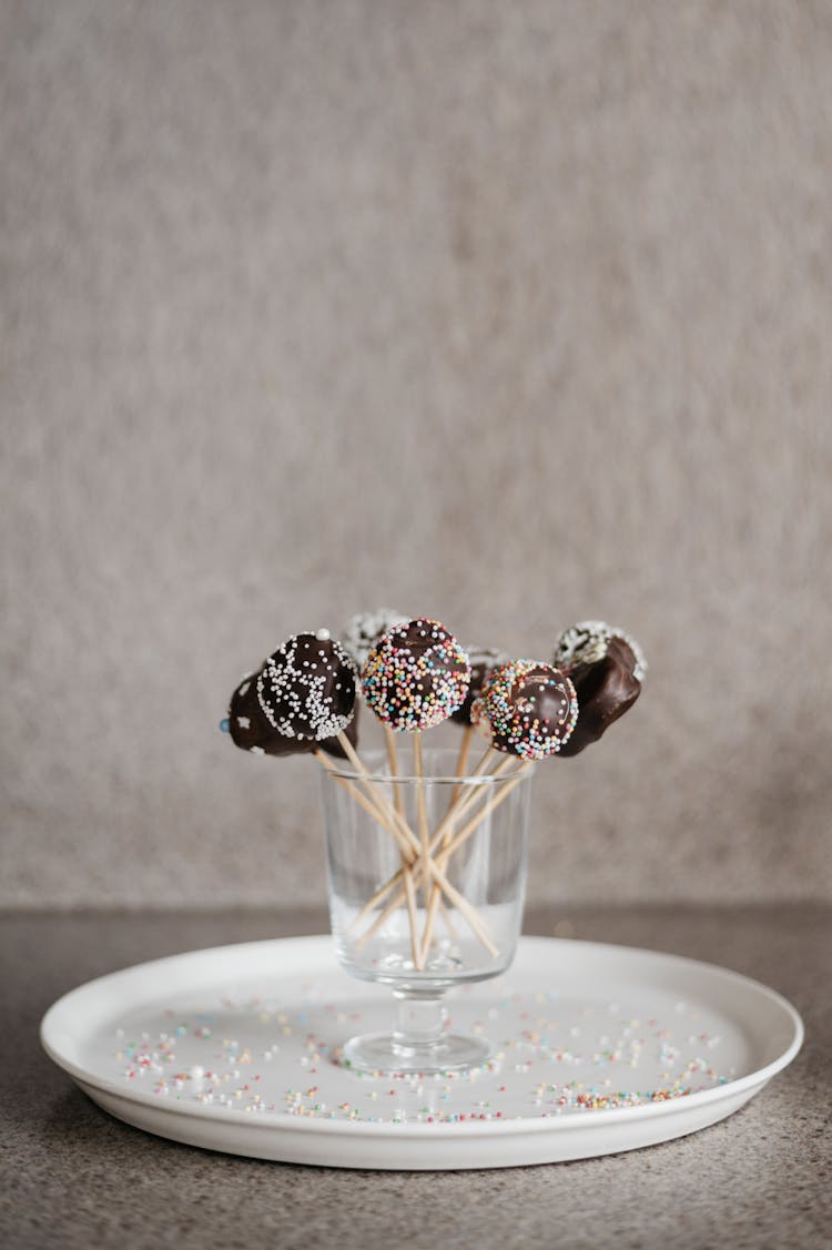 Chocolate Lollipops In A Glass On A White Plate