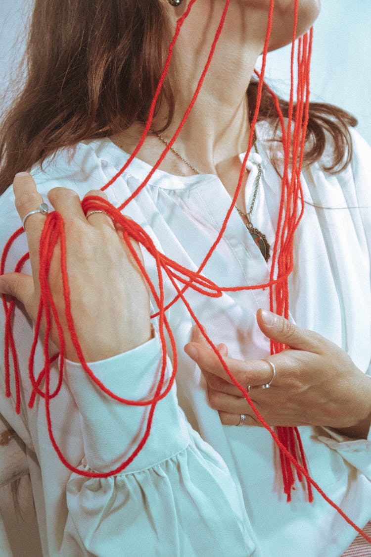 Conceptual Photograph Of A Woman With Red Strings Attached To Her Face 