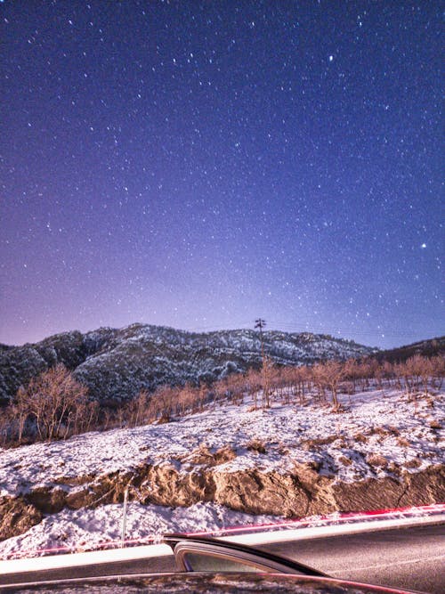 Stars on Clear Sky over Hill in Winter