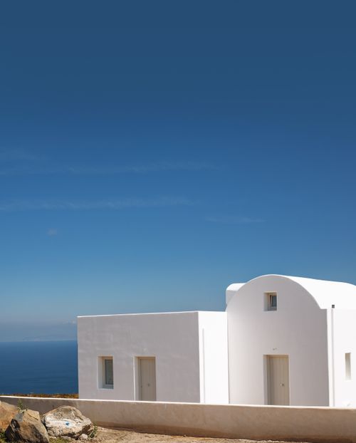 Free Serene white Mediterranean building against a clear blue sky, overlooking the sea. Stock Photo