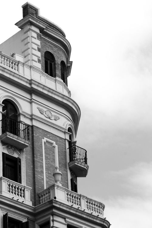 Free A detailed black and white view of a historical urban building facade with classic architecture and ornate balconies. Stock Photo