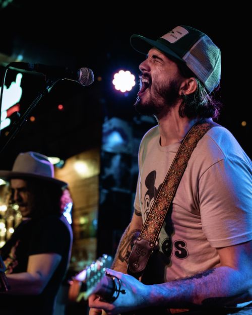 Free Dynamic live music scene featuring a passionate rock singer and guitarist on stage in Orlando. Stock Photo