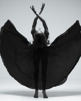 Captivating modern dance pose with flowing fabric in a studio setting.