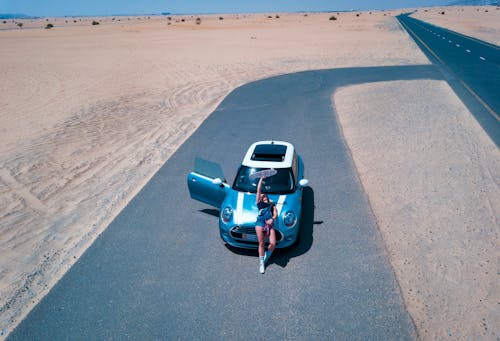 Person Leaning on Teal Mini Cooper