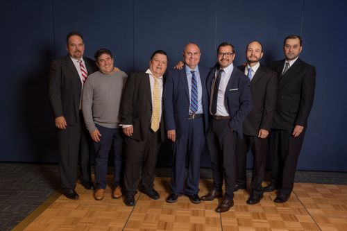Free Seven men dressed formally pose together, exuding professionalism at a corporate event. Stock Photo