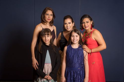 Free Charming family portrait showcasing two women and three girls in elegant attire. Stock Photo